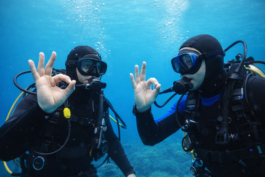 Subacquei che fanno il segnale OK sott’acqua durante un’immersione